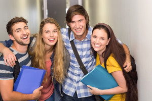 Students holding folders at college corridor