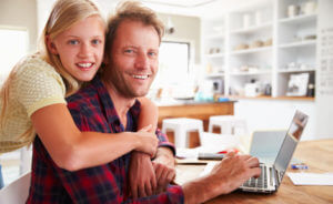 père et fille devant un ordinateur sur un bureau